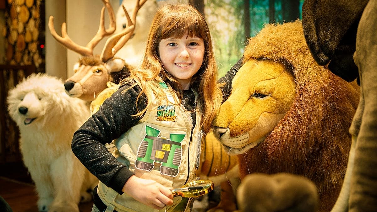A young girls next to a life size lion